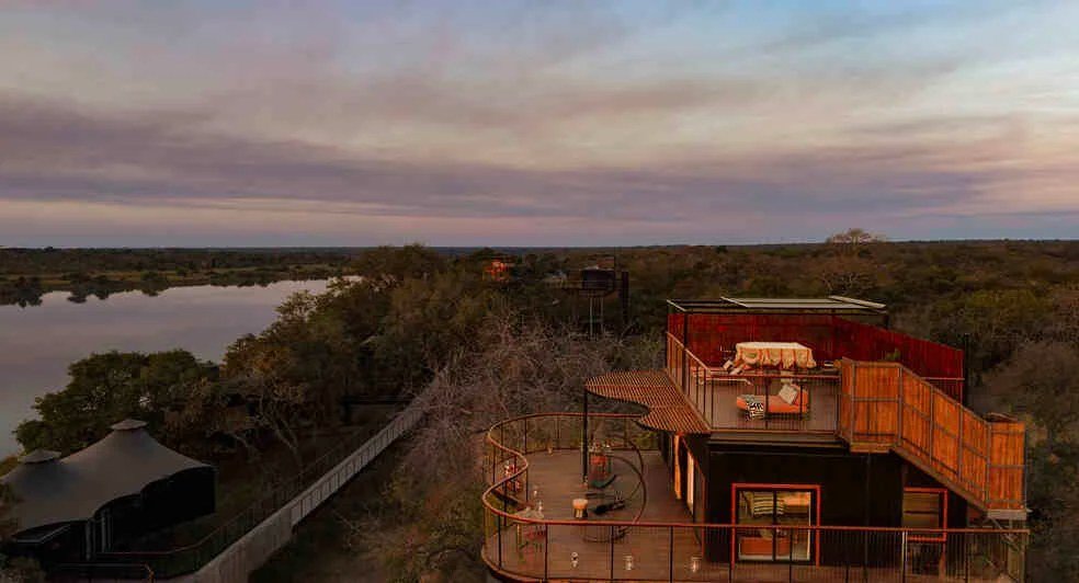 A raised lounge deck overlooks the river at dusk near Anantara Tented Camp Kafue River.