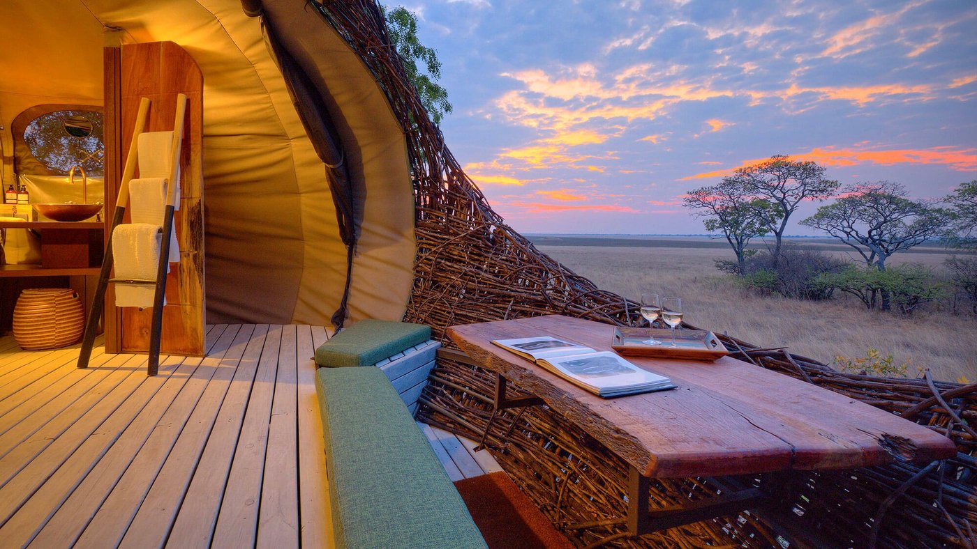 Woven walls curve around a desk inside a nest room at Chisa Busanga Camp.