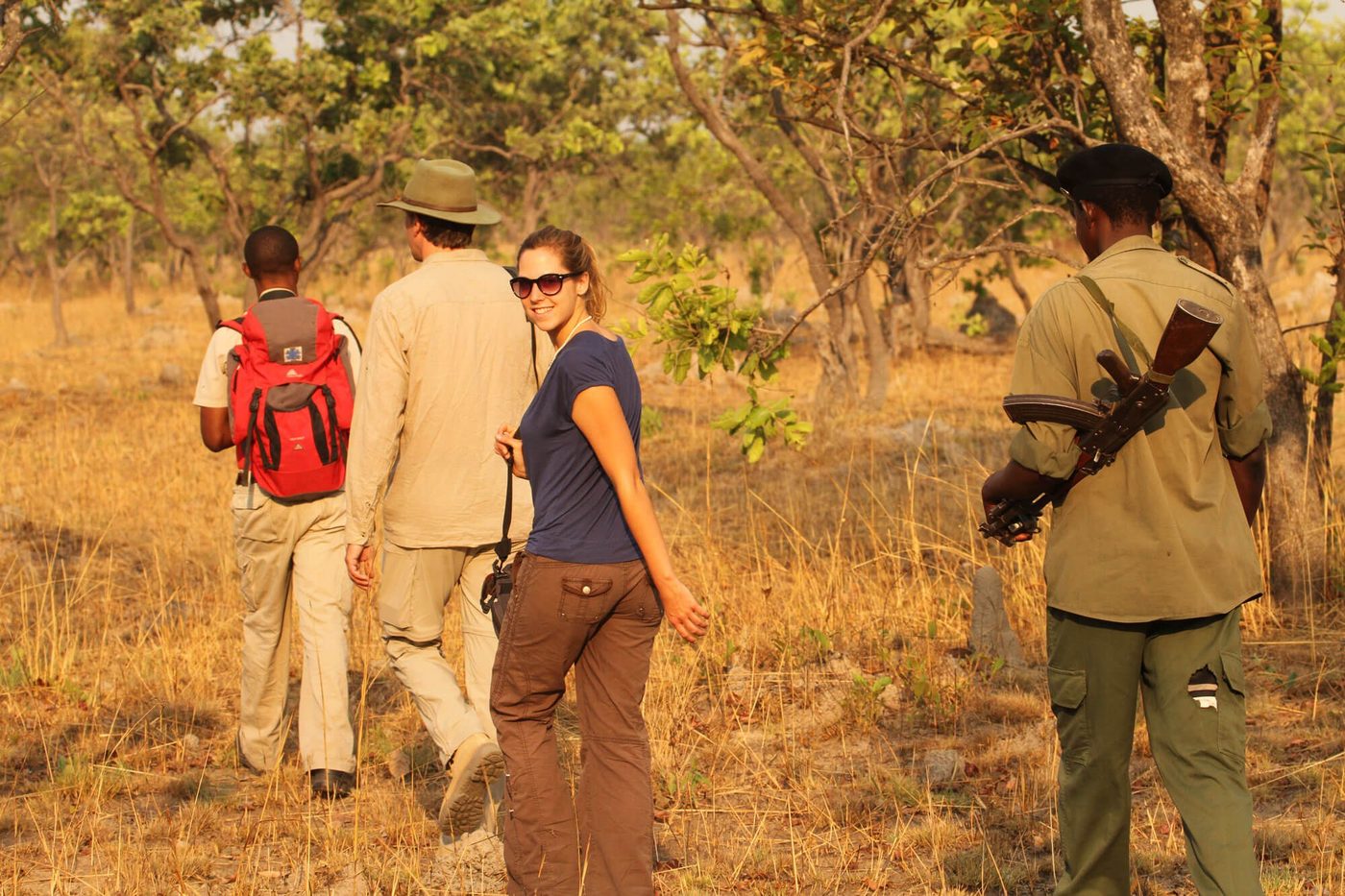 Guests follow an armed ranger on a walking safari near Hippo Lodge.