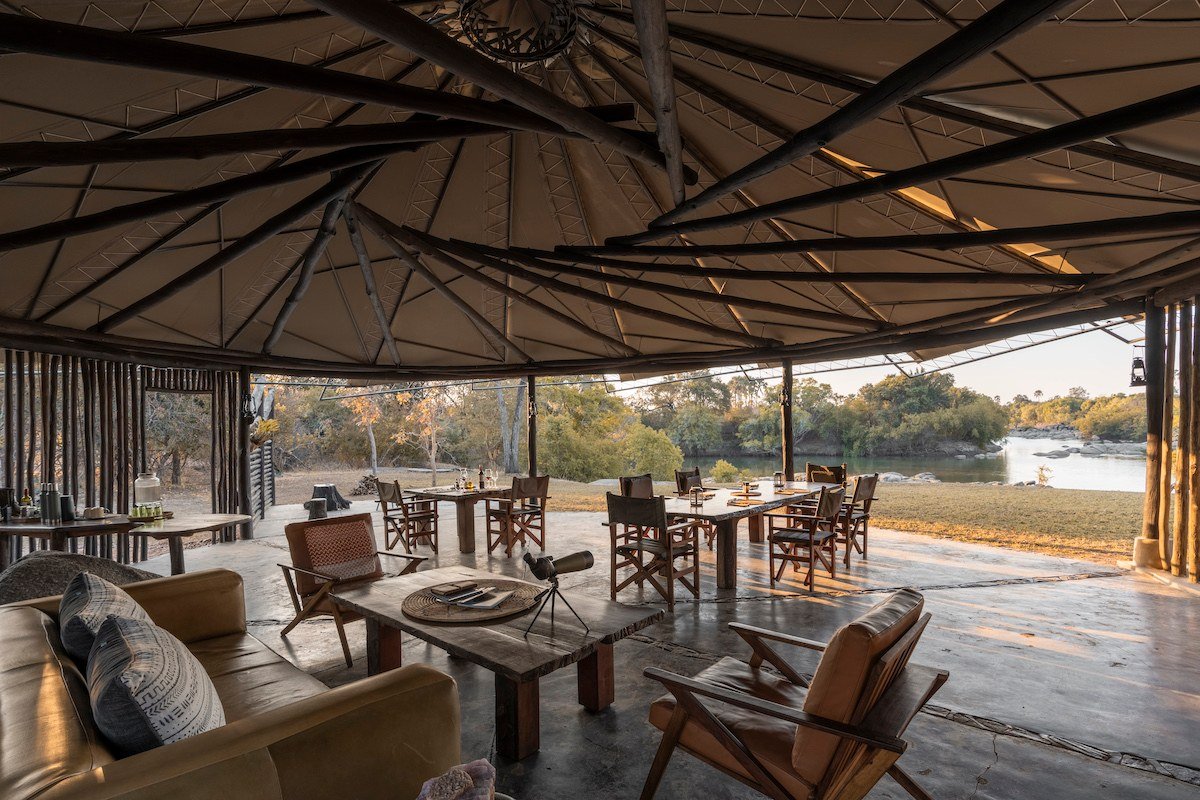 Cushioned seating fills the open-air dining pavilion at Kasabushi Camp.