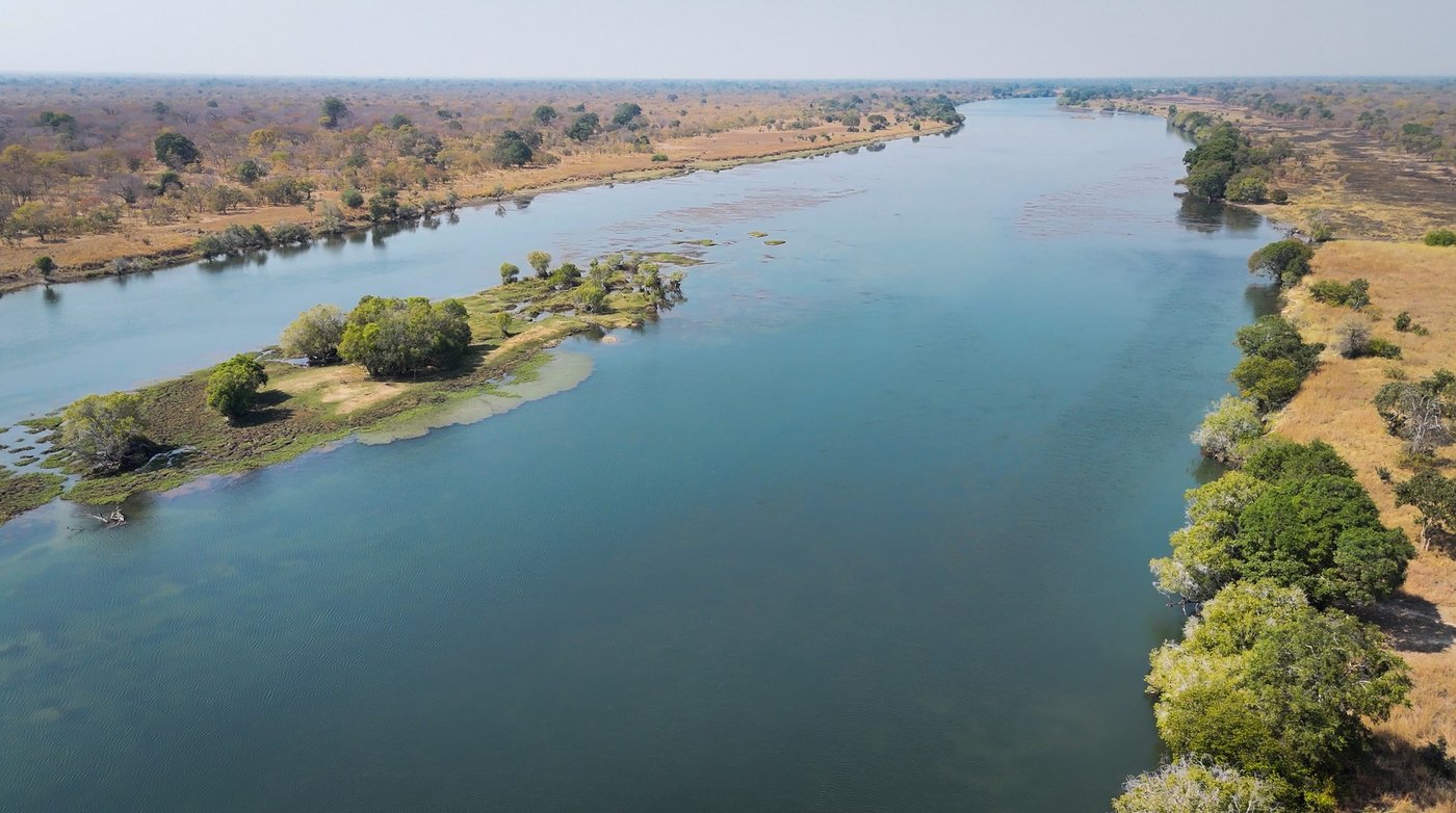 An aerial view traces a bend of the Kafue River past Lwenge River Camp.