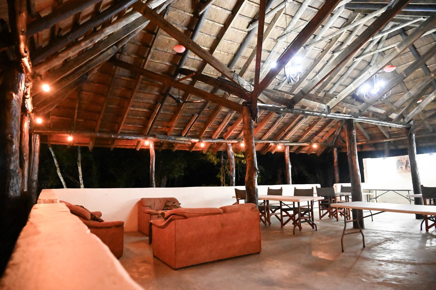 Leather sofas fill the open-air lounge under a thatch roof at Mapunga Bush Camp.