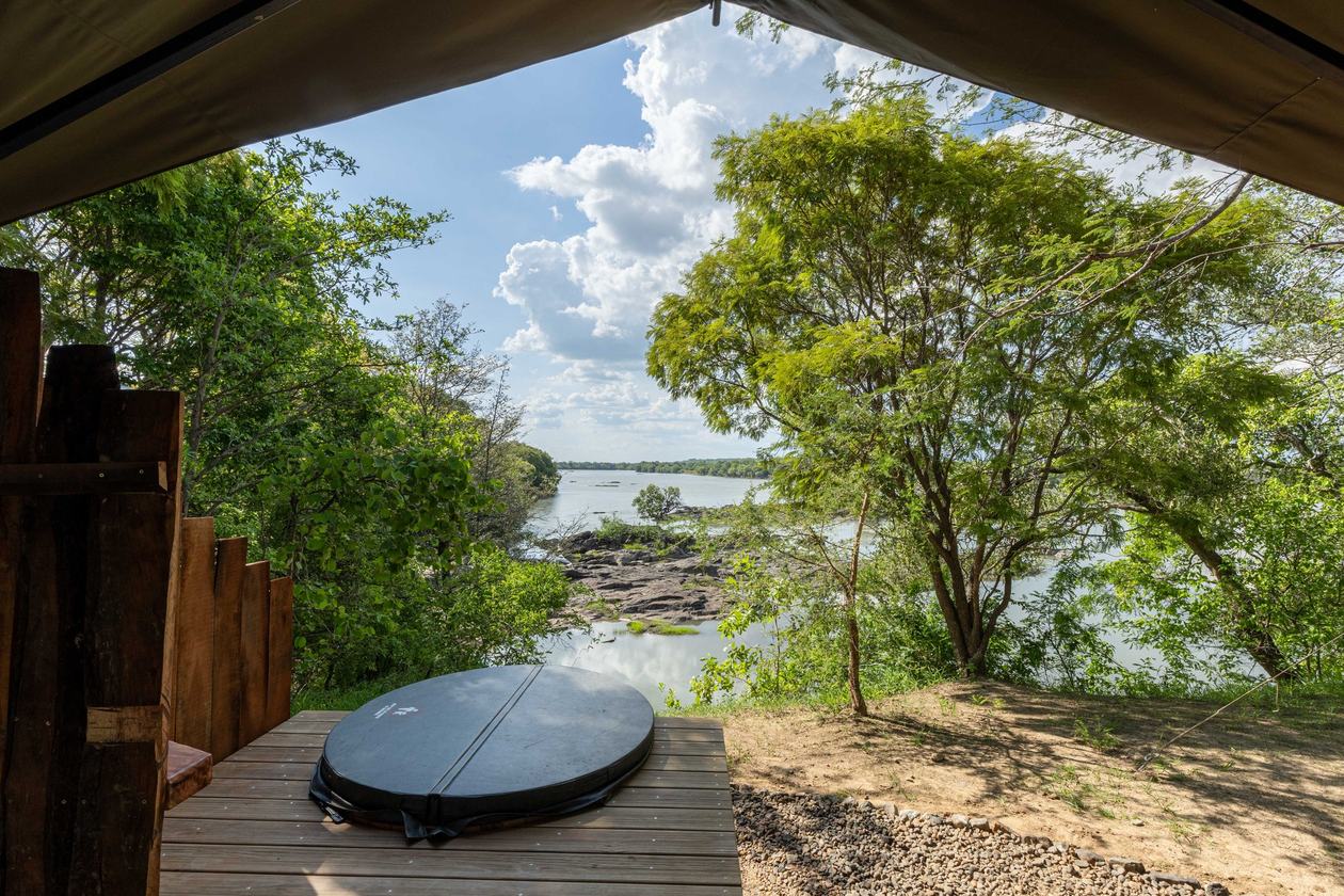 A tent opening frames a view of the river at Mawimbi Bush Camp.