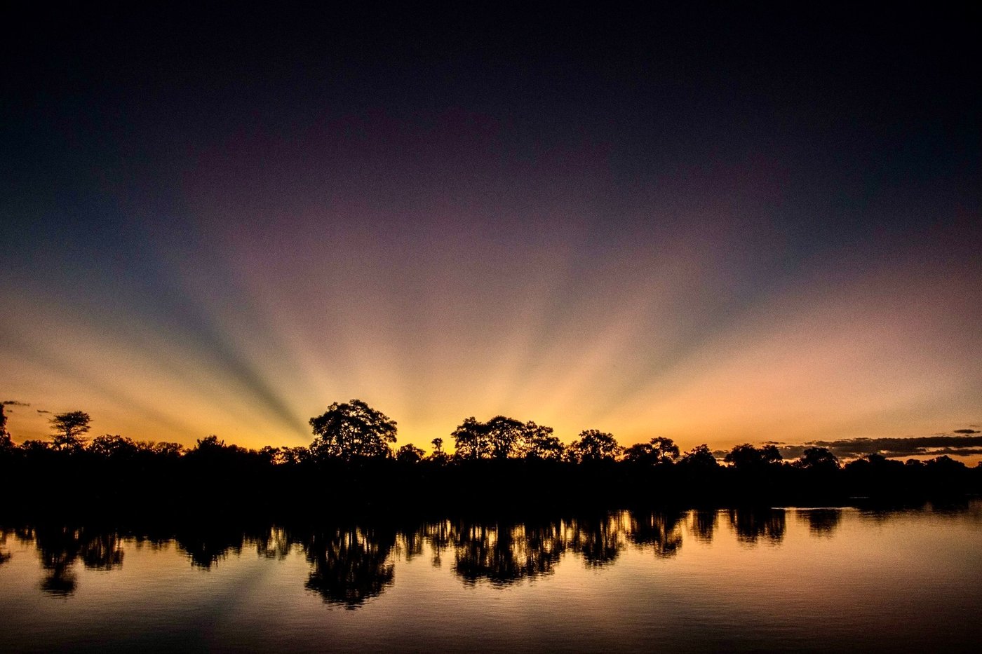 The sun rises over still water near McBrides' Camp.