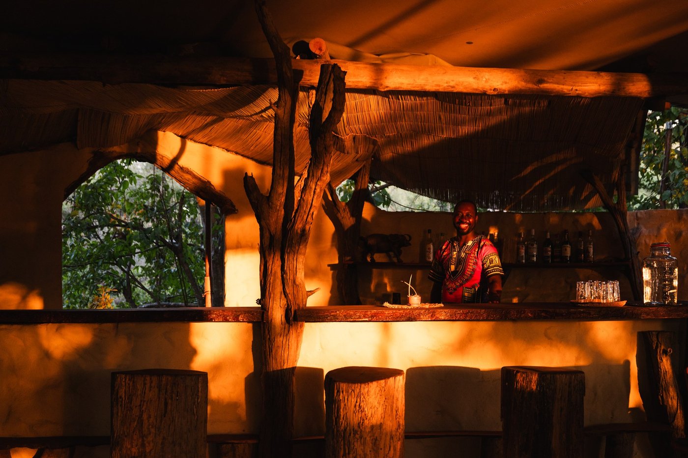 The open-sided bar glows warmly after dark at Musekese Camp.