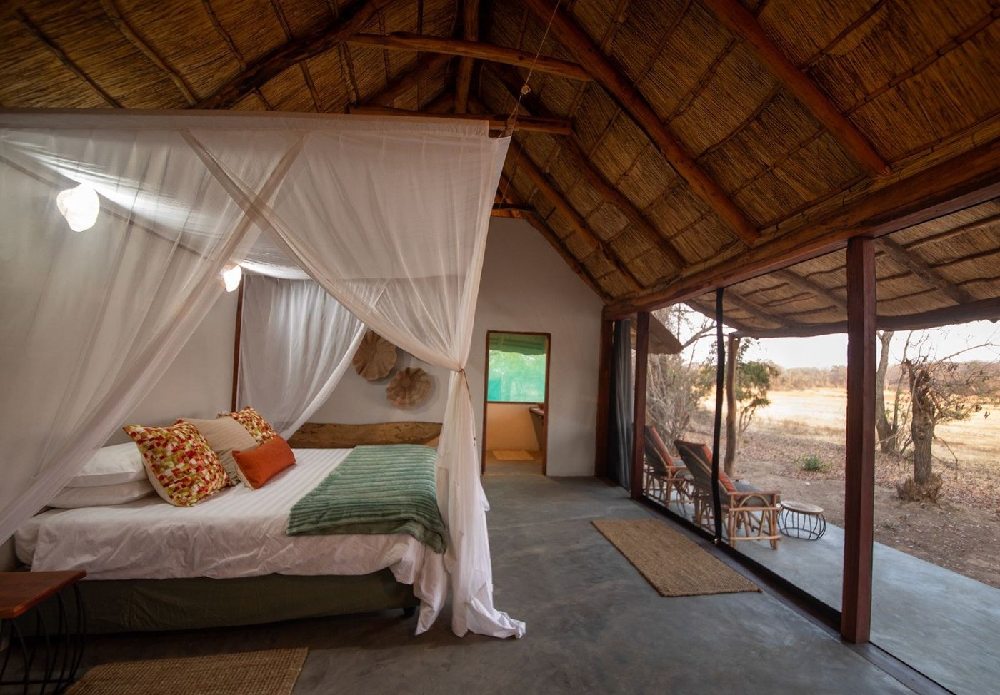 A mosquito net hangs over the bed in a tented room at Nanzhila Lake Camp.