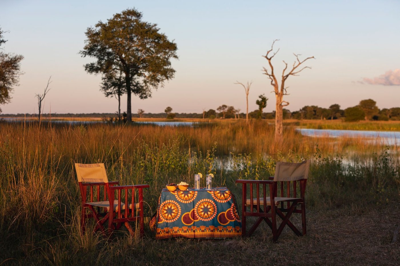 Two patterned chairs overlook the wetland from camp at Nanzhila Lake Camp.