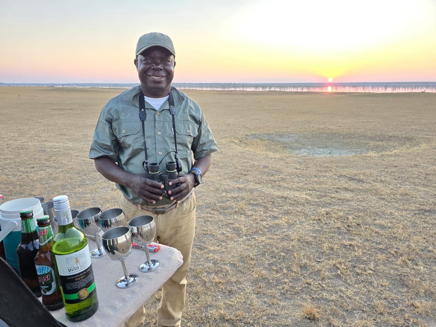 A guide sets out drinks for sundowners at Nanzhila Lake Camp.