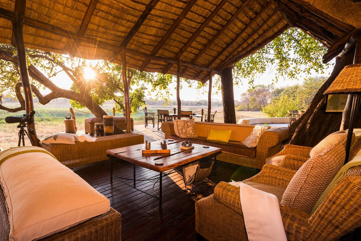 Woven armchairs fill the open-sided lounge at sunrise at Nanzhila Plains Camp.