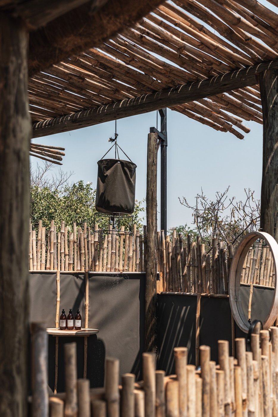 An open-air bush shower sits under thatch at Ntemwa-Busanga Camp.
